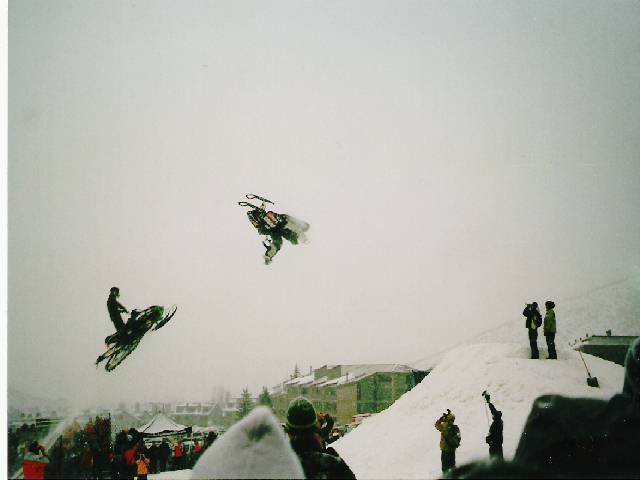 backflip on a snowmobile with someone right on his tail