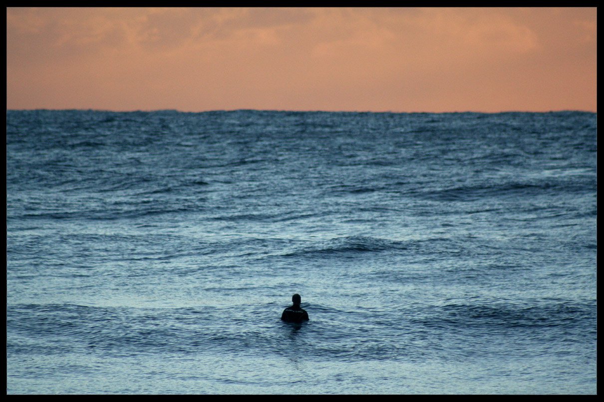 Lone surfer at sunrise